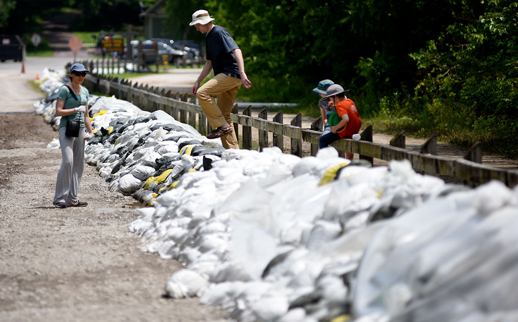 Jon Klaas scales a sandbag mound with his wife, his son and his daughter